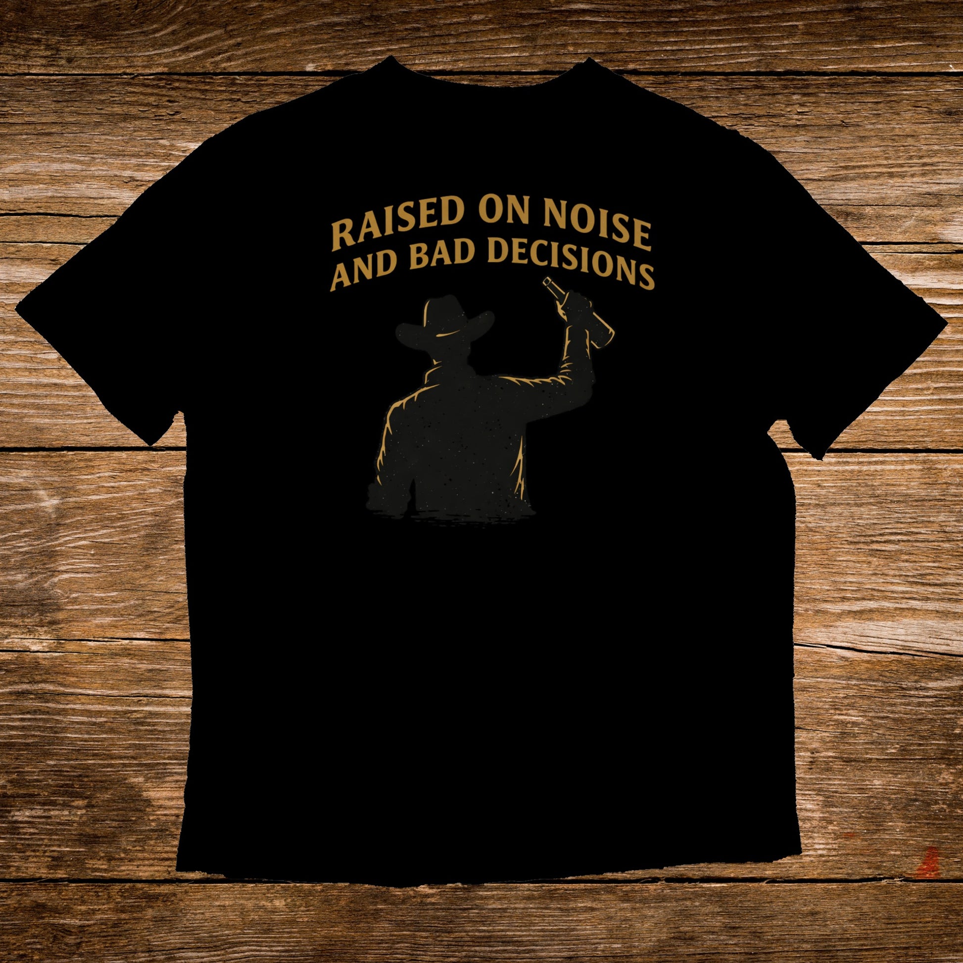 Black t-shirt with silhouette of a cowboy and text "Raised on noise and bad decisions".