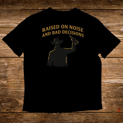 Black t-shirt with silhouette of a cowboy and text "Raised on noise and bad decisions".