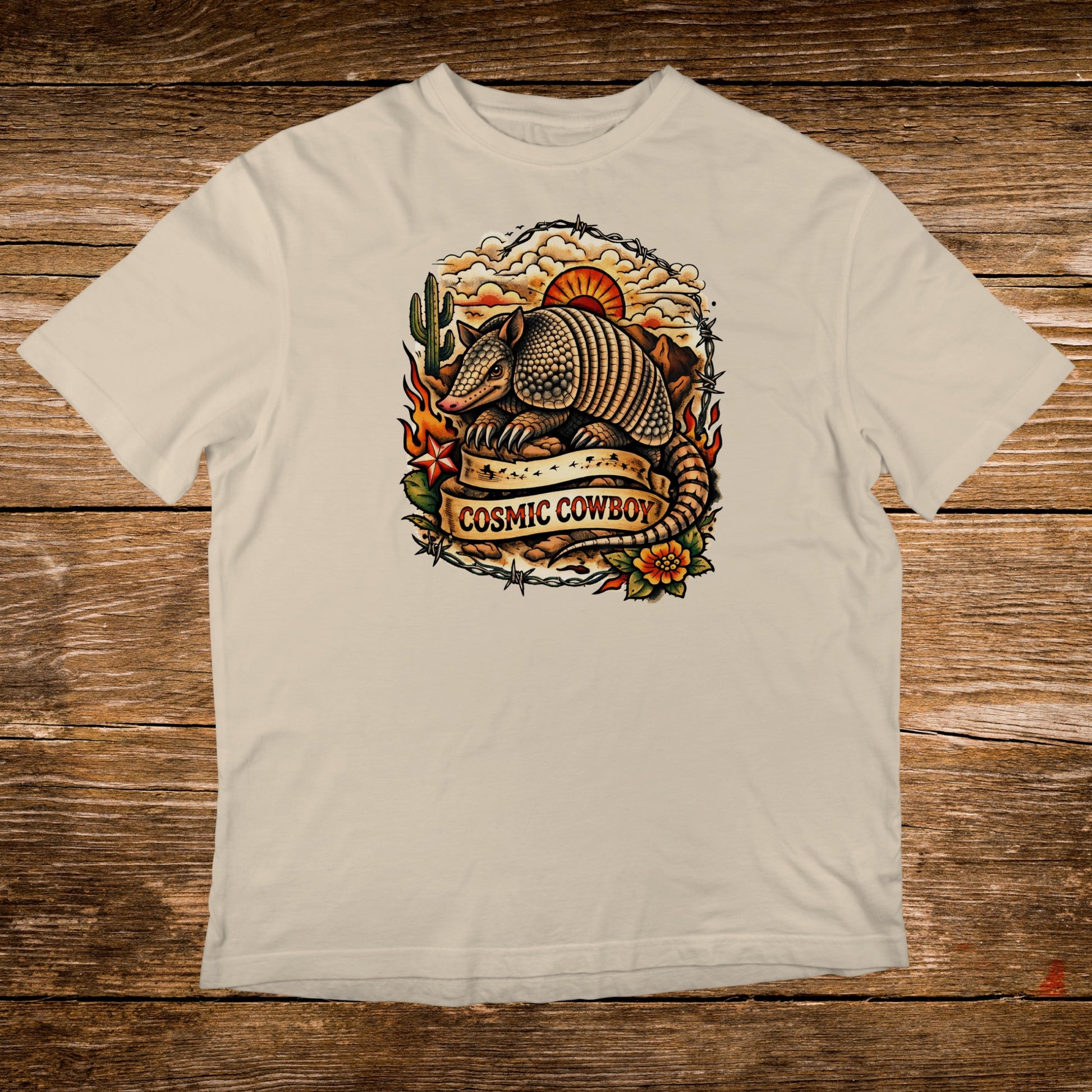 Armadillo with "Cosmic Cowboy" banner against barbed wire and sunset.