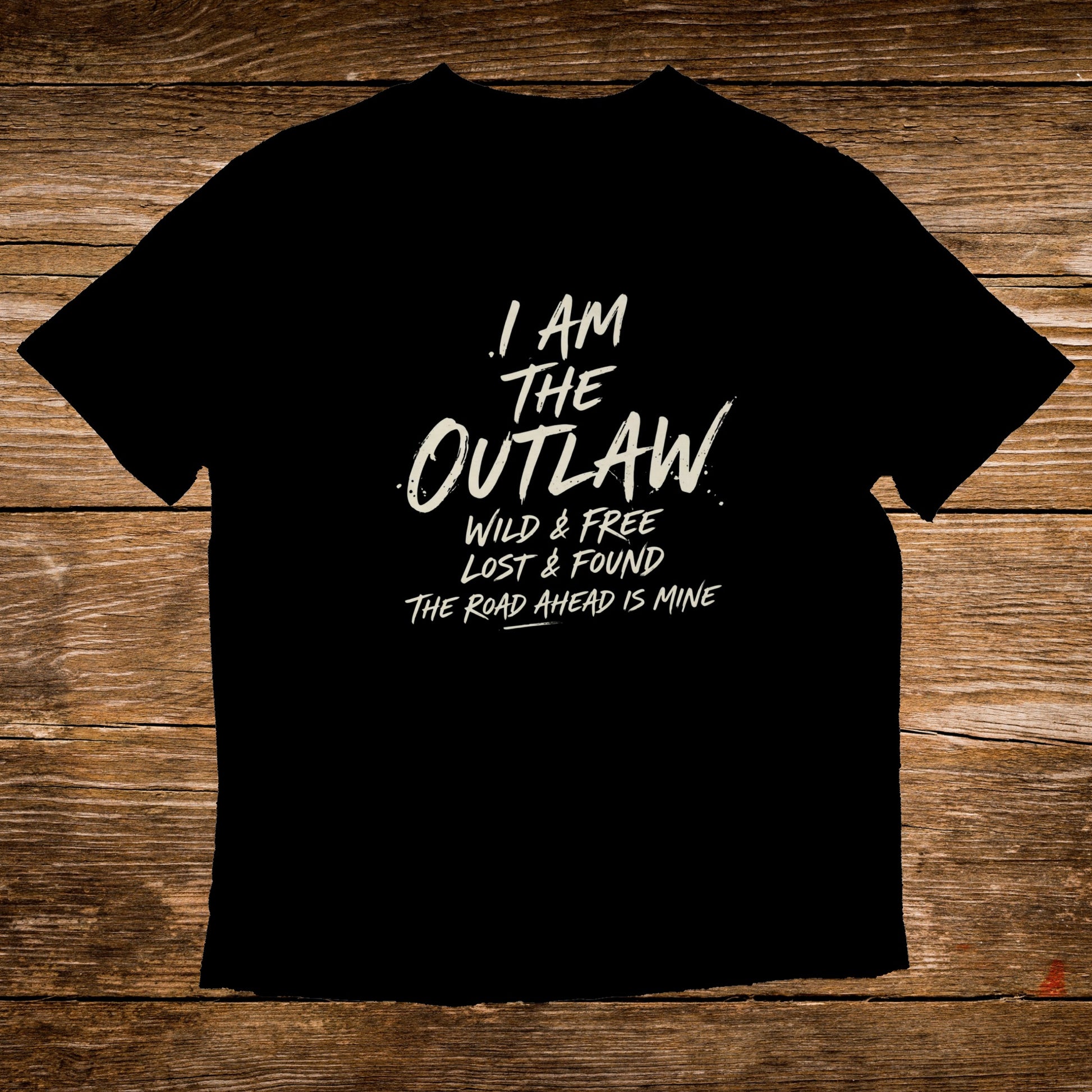 Black t-shirt with white text reading "I AM THE OUTLAW WILD & FREE LOST & FOUND THE ROAD AHEAD IS MINE".