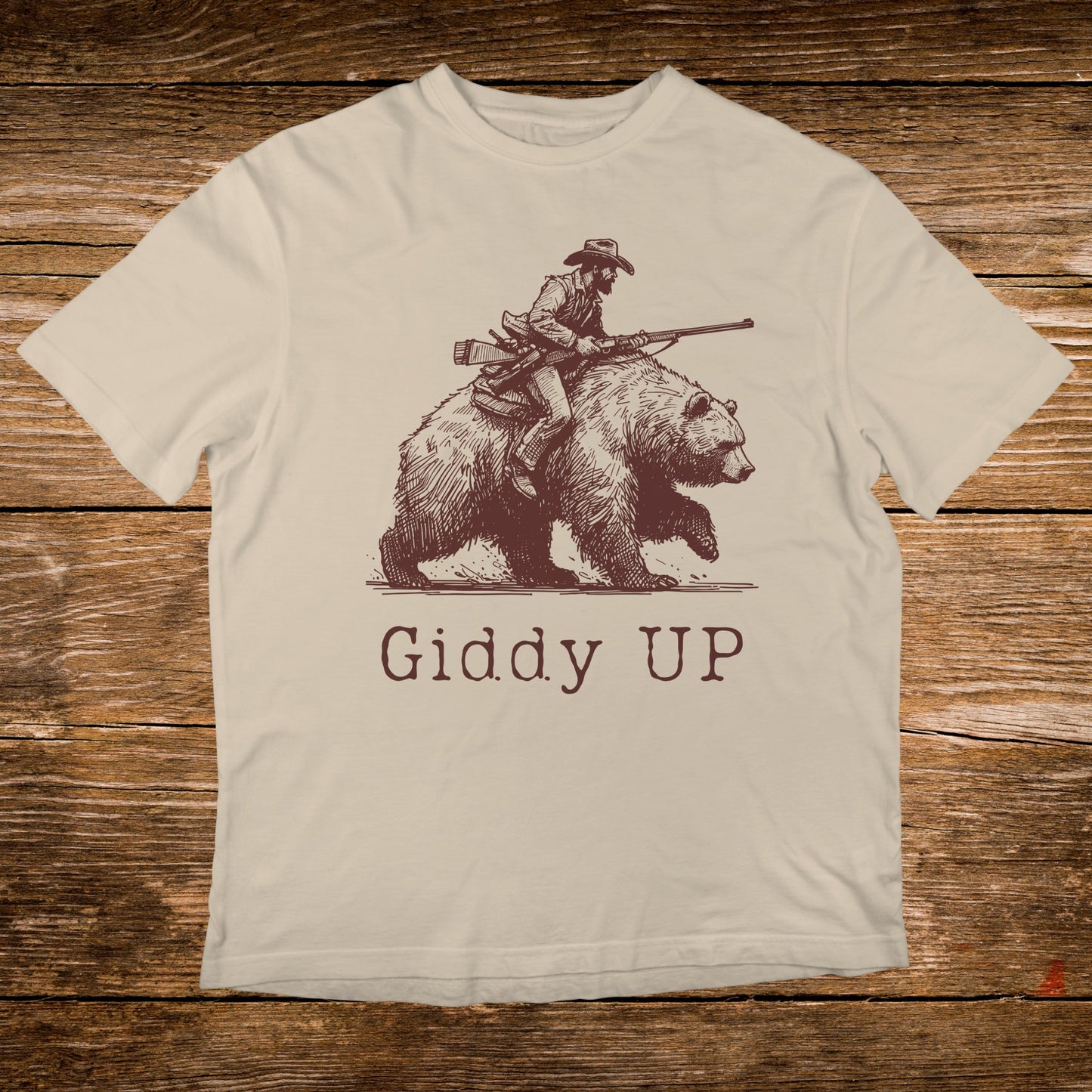 Line art of cowboy riding a bear with text "GIDDY UP".