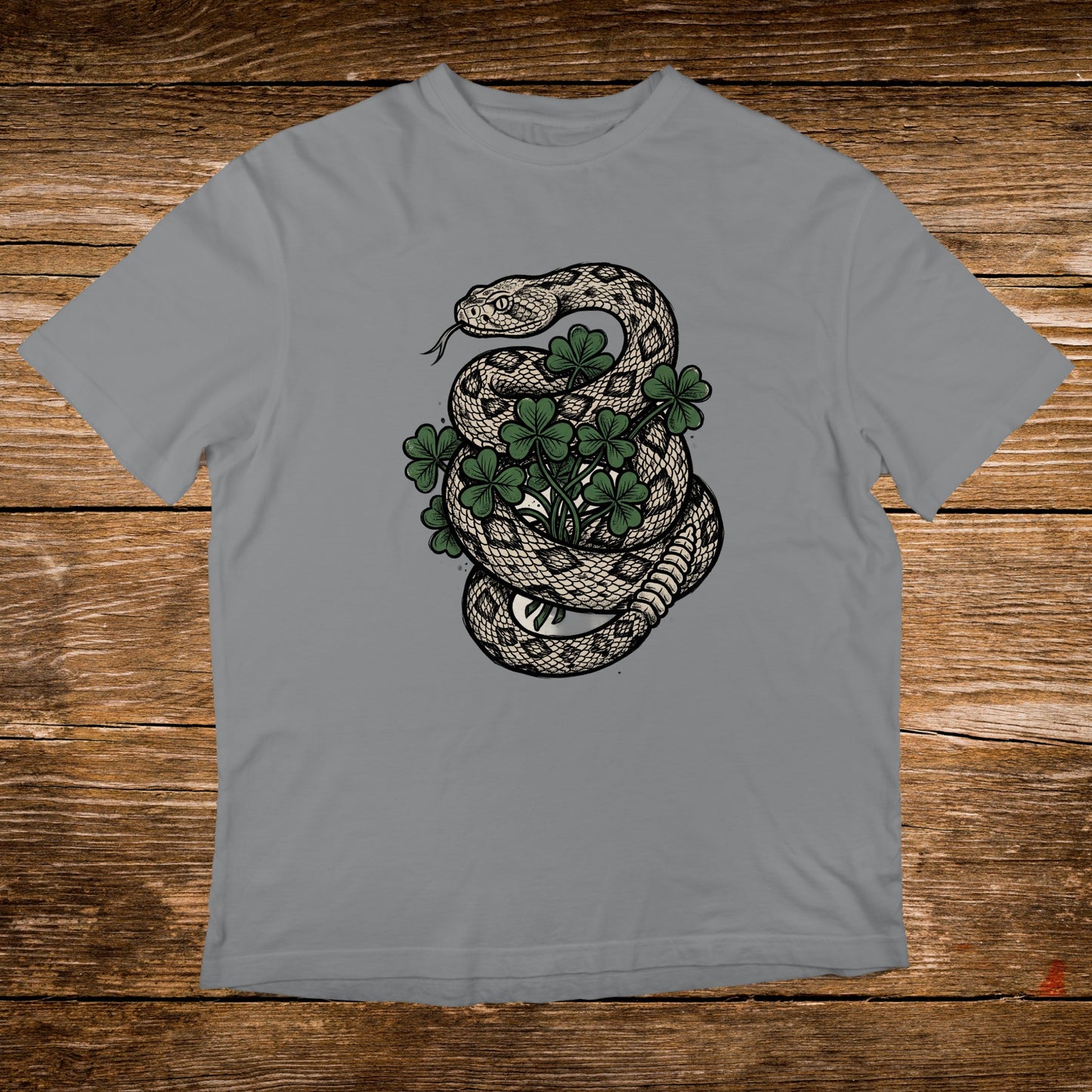 Snake coiled around a shamrock plant on a grey t-shirt.