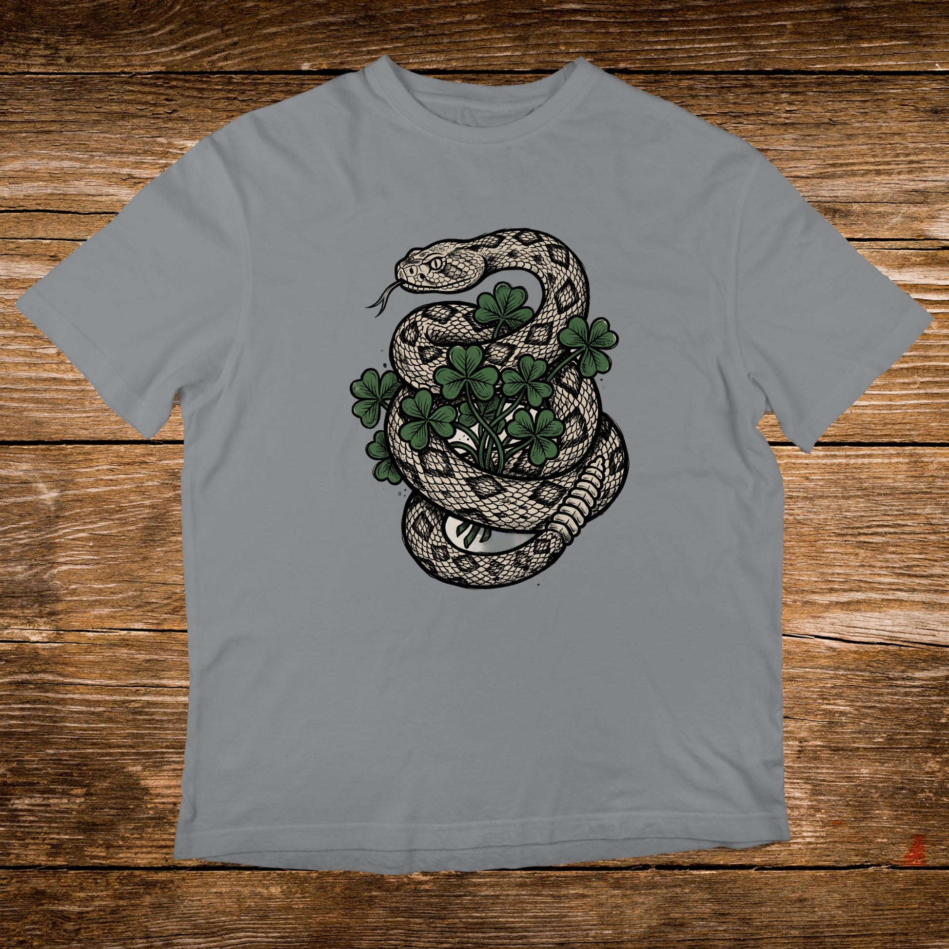 Snake coiled around a shamrock plant on a grey t-shirt.