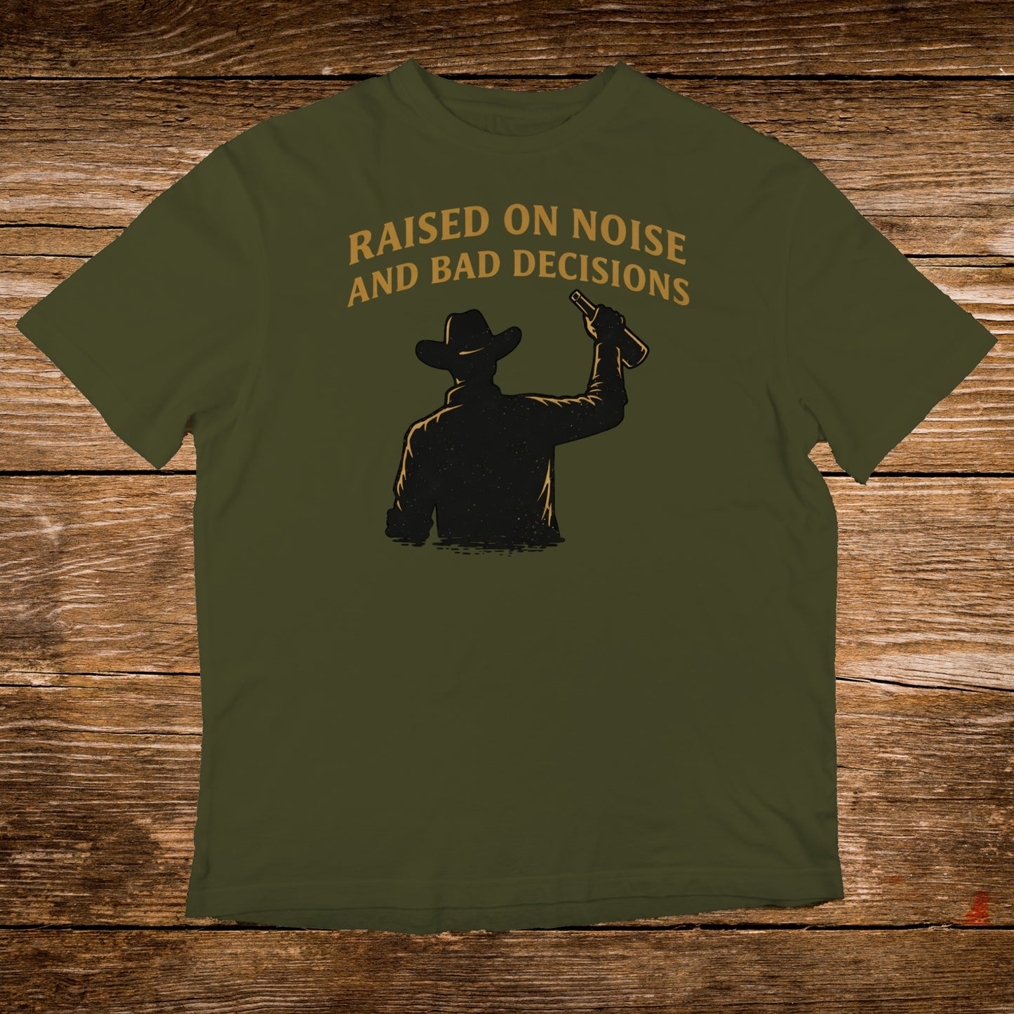 Olive green t-shirt with cowboy silhouette and "RAISED ON NOISE AND BAD DECISIONS" text.