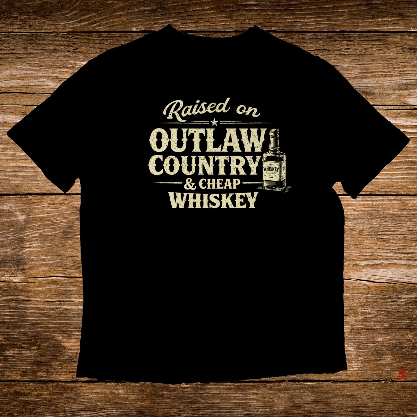 Black t-shirt with "Raised on Outlaw Country & Cheap Whiskey" text and a whiskey bottle graphic.