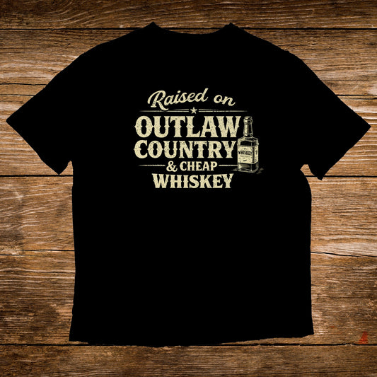 Black t-shirt with "Raised on Outlaw Country & Cheap Whiskey" text and a whiskey bottle graphic.