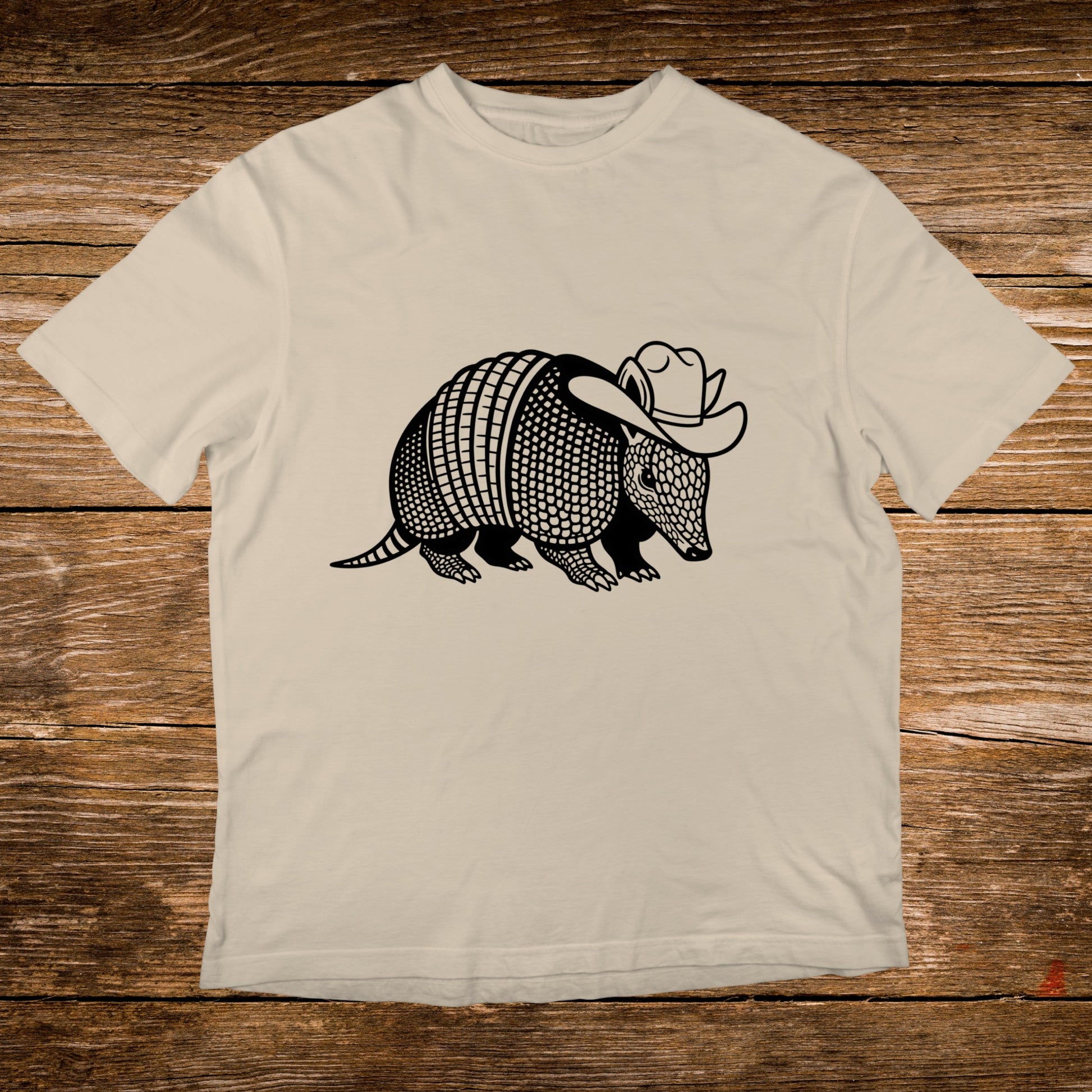 Armadillo wearing a cowboy hat graphic on a cream t-shirt.