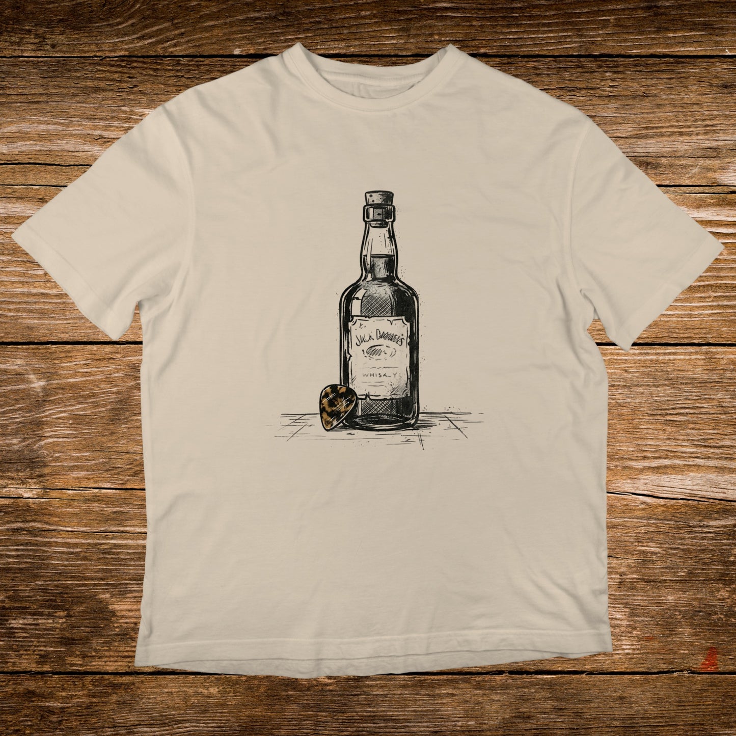 Cream t-shirt with sketch of Jack Daniel's whiskey bottle and guitar pick.