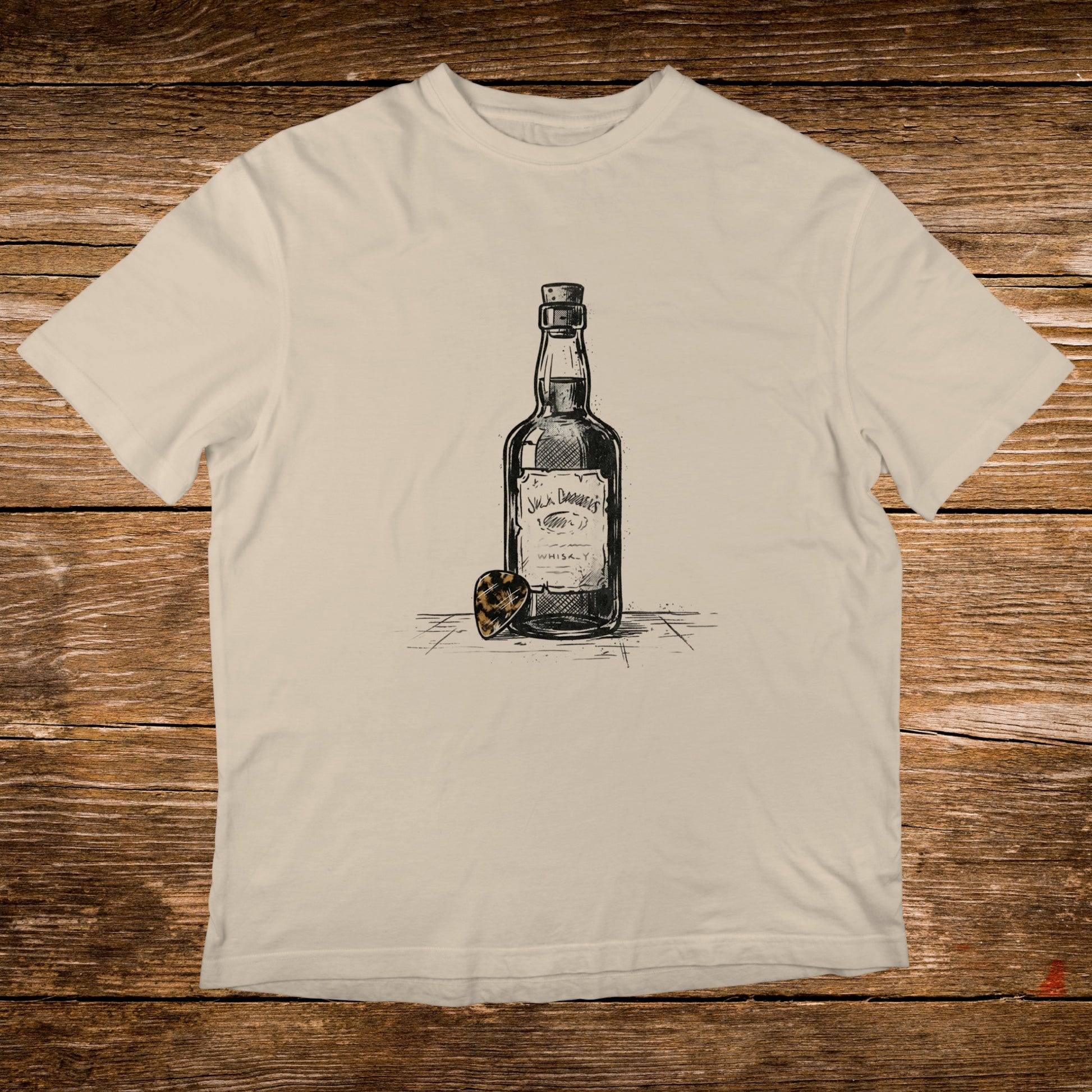Cream t-shirt with sketch of Jack Daniel's whiskey bottle and guitar pick.